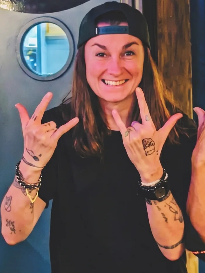 Christelle, la gérante du Canard De Rue, casquette à l'envers derrière le bar